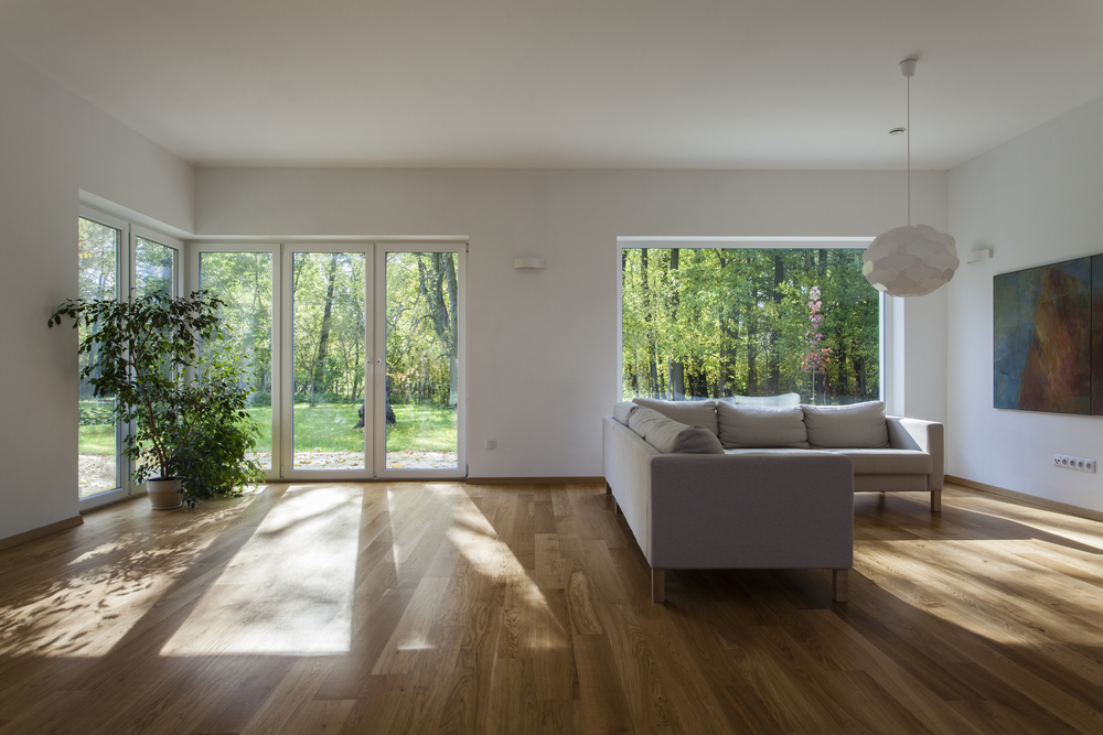 Installation of timber bifolding doors in a room with a wooden floor.